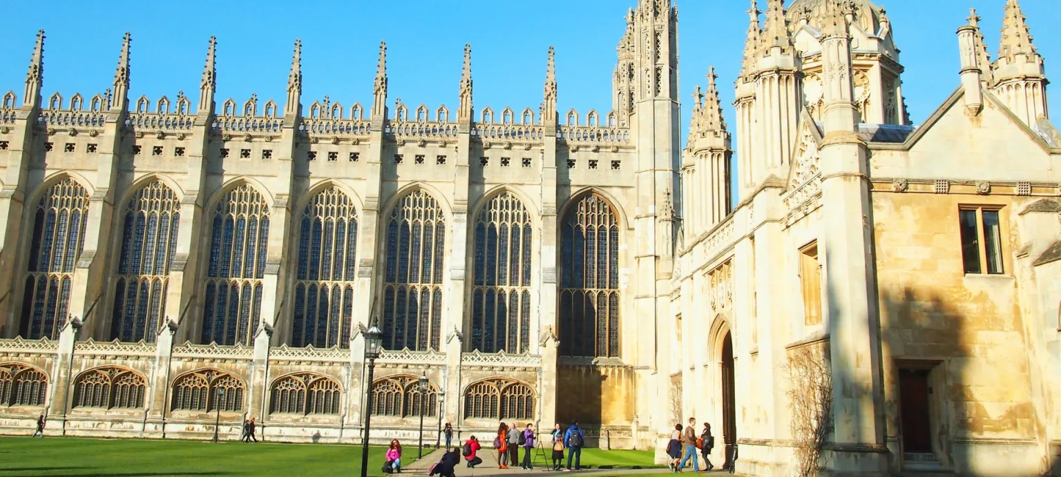 Exterior view of the magnificent King's College Chapel in Cambridge, showcasing its grand Gothic architecture under a clear blue sky.